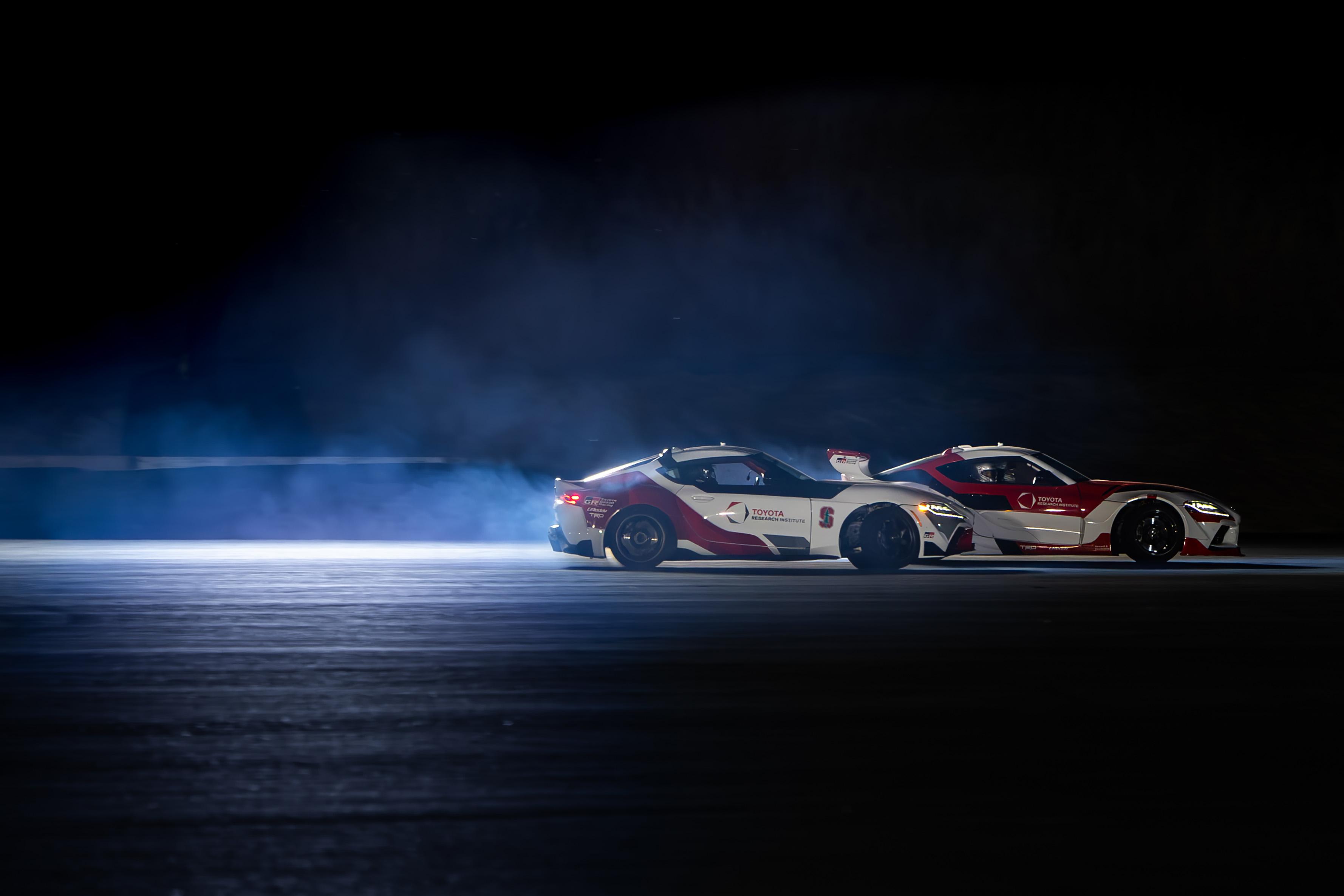 Profile shot of Toyota Supras autonomously tandem drifting.