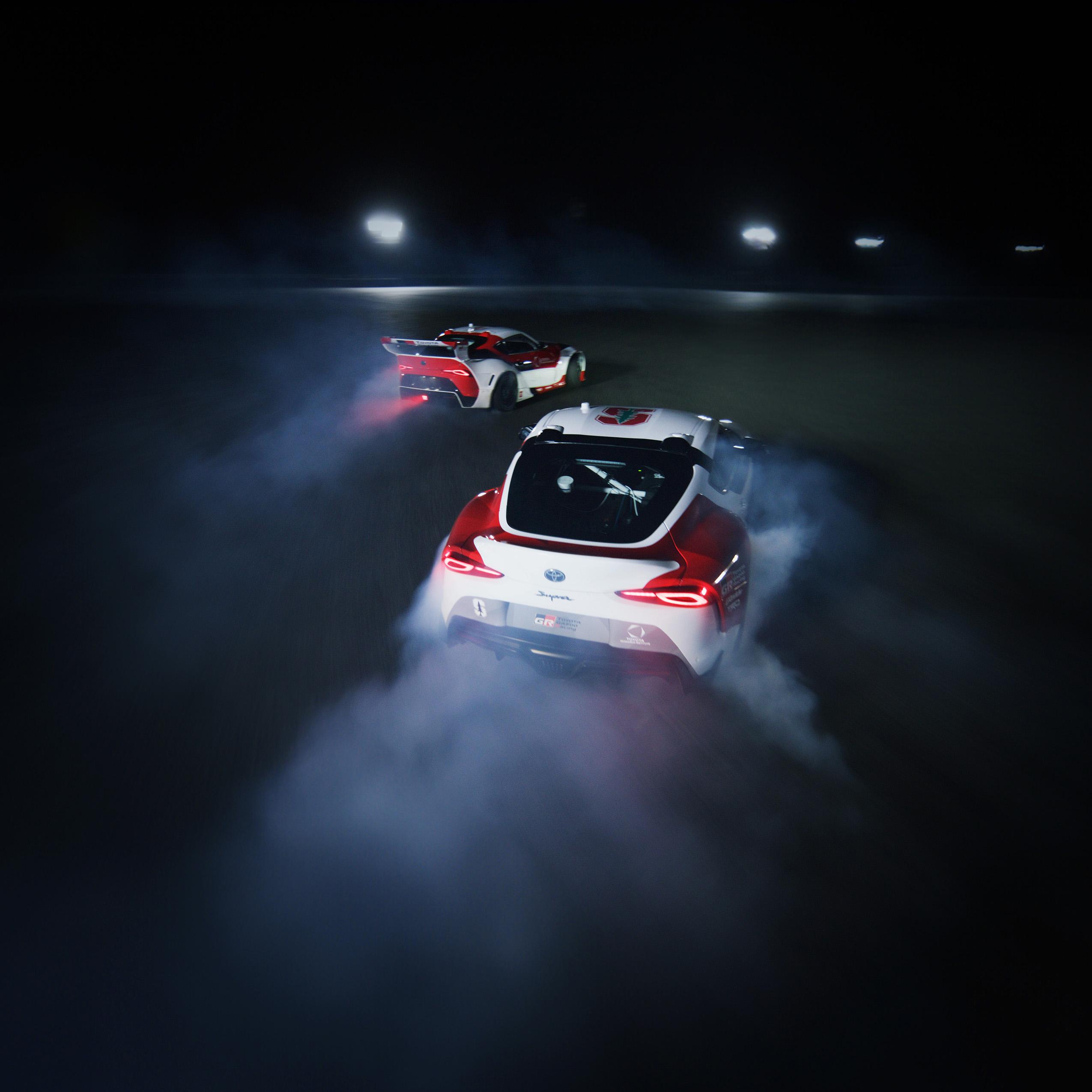 Rear drone view of Toyota Supras autonomously tandem drifting on the skidpad.